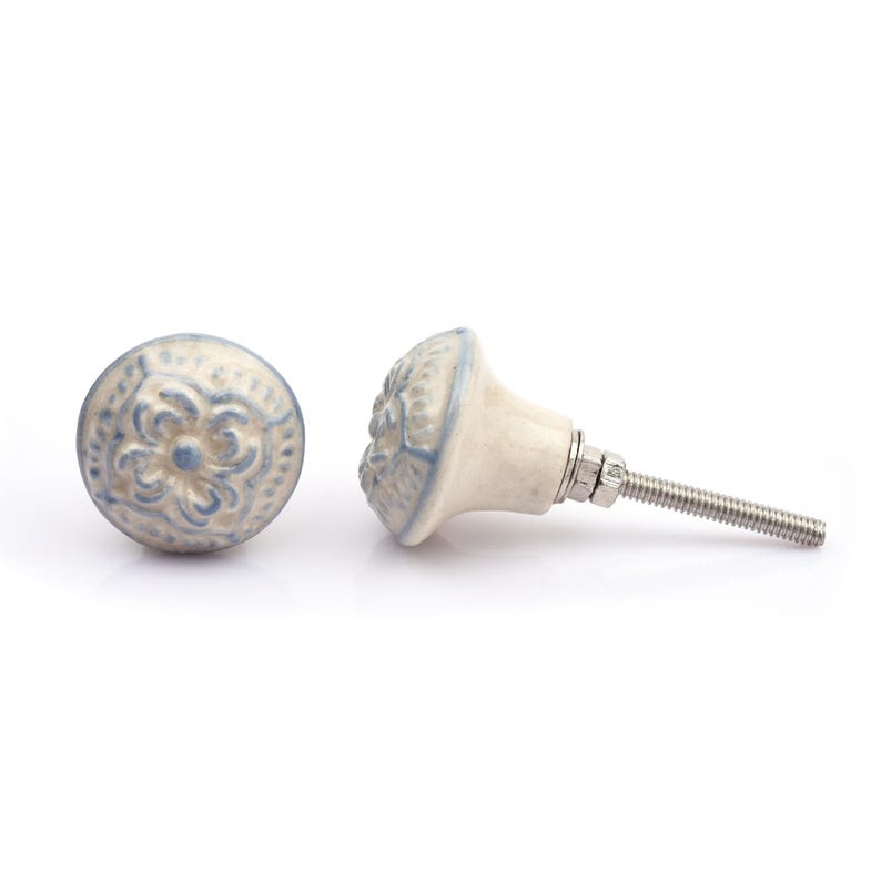 May include: A collection of twelve decorative cabinet knobs in various colours and patterns. Each knob features a round or oval shape with a metal bolt extending from the back. The designs include floral, geometric, and solid textures in shades of green, blue, orange, purple, white, and grey.