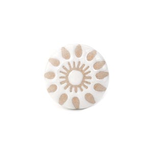Könnte beinhalten: Ein runder Keramik-Möbelknopf mit weißer, glänzender Oberfläche und einem zentralen Sonnenstrahlenmuster. Das Design besteht aus einem kleinen weißen Mittelkreis, umgeben von strahlenförmigen Linien und zwölf beigen Blütenblättern.