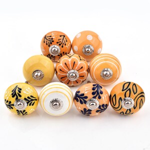 Hand-painted ceramic round knobs in yellow and orange with floral; dresser knobs and cabinet pulls for furniture hardware.