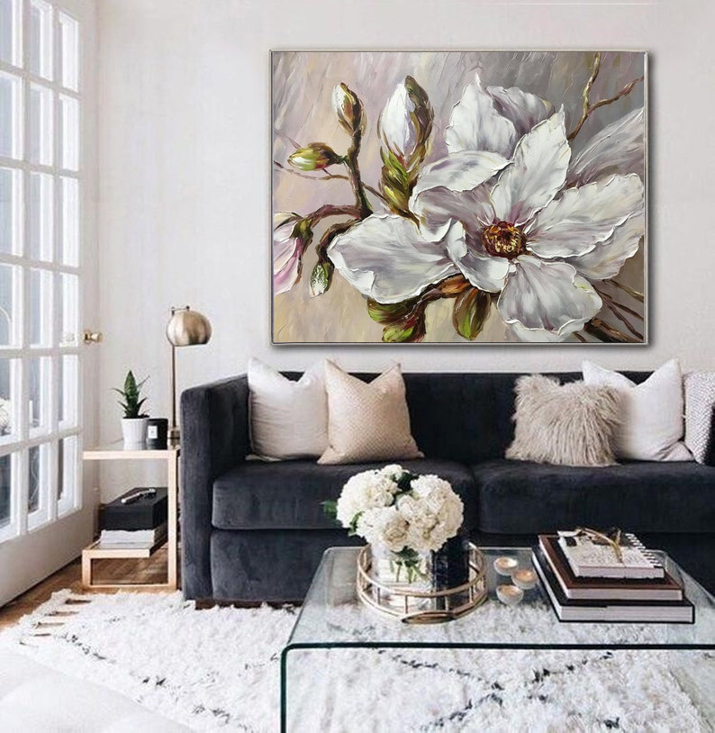 May include: A painting of a white magnolia flower with green leaves and buds on a light gray background.