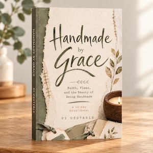 May include: A hardcover book titled Handmade by Grace by Di Oesterle. The cover features a cream-colored textured paper overlay with torn edges, dark green accents, stitched details, and botanical illustrations of leaves.