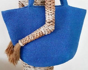 May include: A large, blue, woven tote bag with a thick, woven handle. The bag is made of a tightly woven material and has a slightly rounded shape.