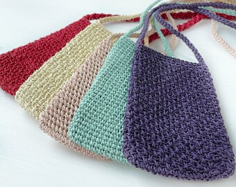 May include: Five crocheted bags in different colors, including red, beige, pink, light green, and purple. The bags are made with a textured stitch and have long straps.