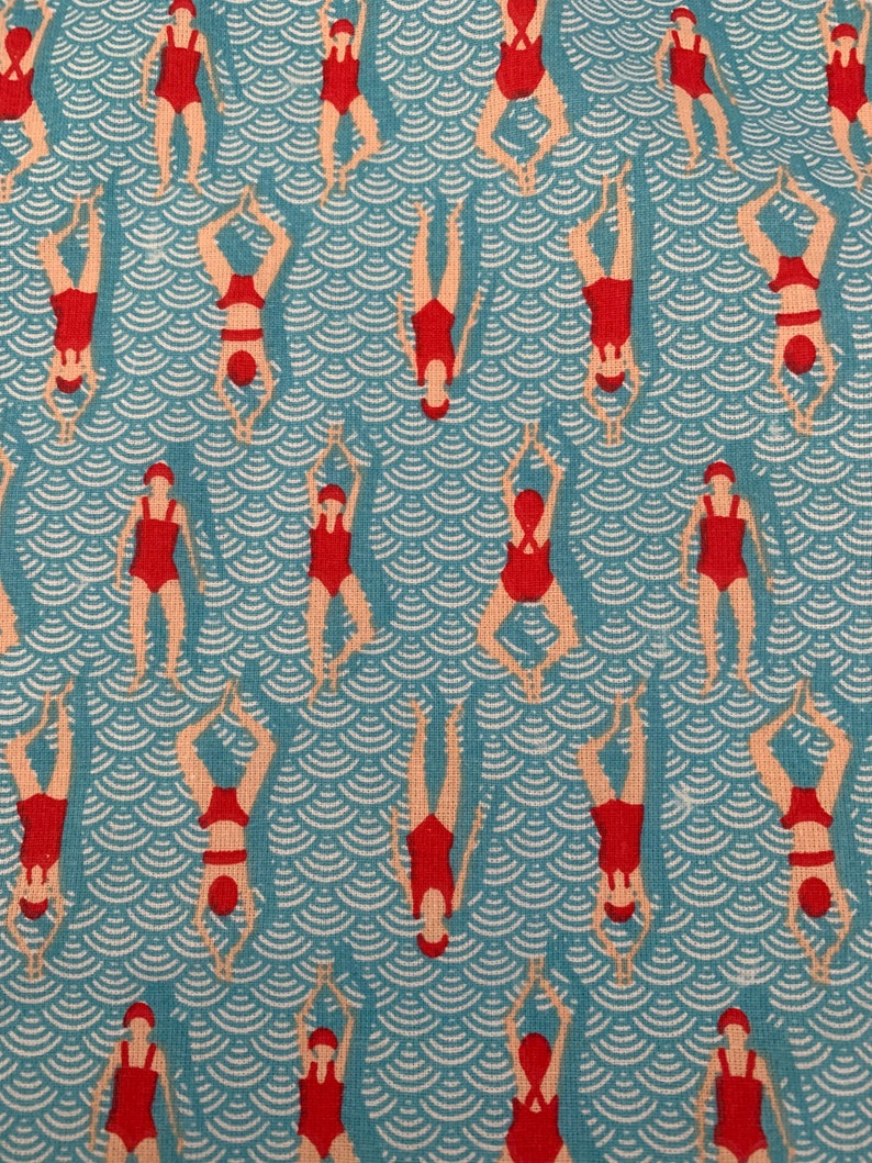 May include: A blue and white fabric with a repeating pattern of red figures swimming in a wavy pattern.