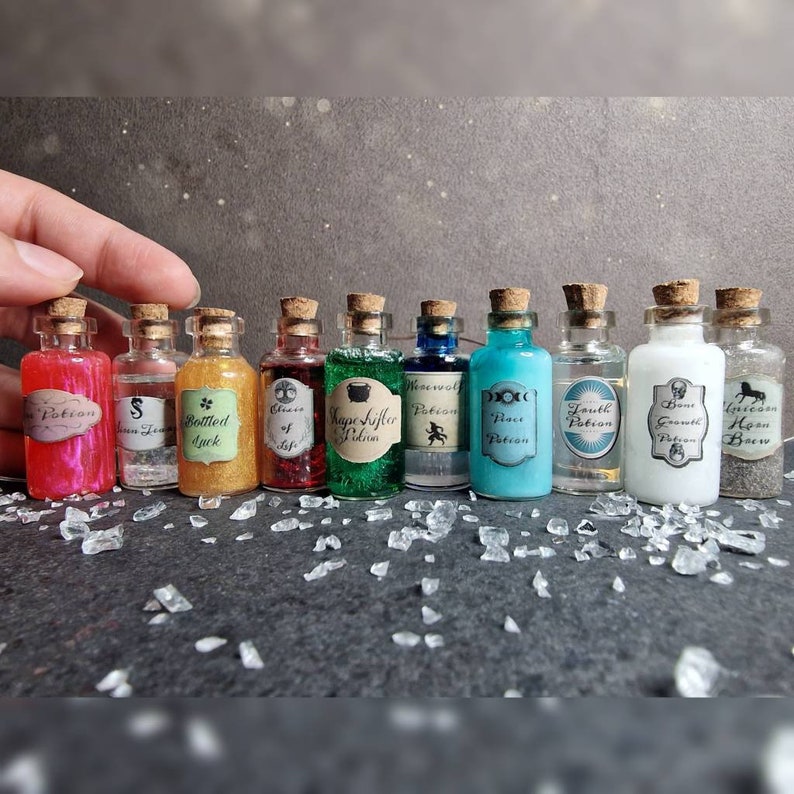 May include: Ten small glass bottles with cork stoppers filled with colorful liquids and glitter. Each bottle has a label with a handwritten name, such as "Bottled Luck", "Truth Potion", and "Growth Potion".