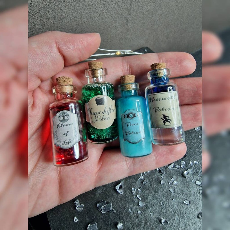 May include: Four small glass bottles with cork stoppers and labels. The bottles contain different colored liquids and have labels that read "Elixir of Life", "Shape-shifting Potion", "Peace Potion", and "Werewolf Potion".
