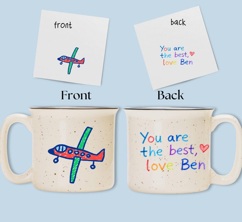 May include: A speckled ceramic mug with a black rim, featuring a hand-drawn airplane on the front and the text "You are the best, love Ben" on the back. The airplane is red, green, and blue.