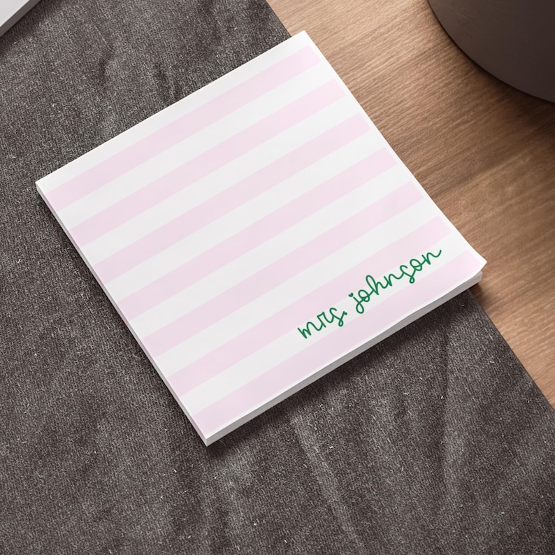 May include: Pink notepad with white stripes and the text "mrs. johnson" in green cursive.