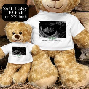 May include: Two plush teddy bears, one 10 inches and one 22 inches, both wearing white t-shirts with an ultrasound image and the text "Carried for a moment, Loved for a lifetime 9/1/2014".