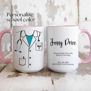 May include: White ceramic mug with a pink rim and handle. The mug features a white coat with a stethoscope, pocket, and a medical symbol. The text on the mug reads "Jenny Price, Winona State University School of Nursing, May 24, 2025, BSN White Coat Ceremony."