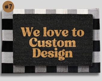 May include: A black doormat with the text "We love to Custom Design" in gold lettering. The doormat is on top of a black and white checked rug.