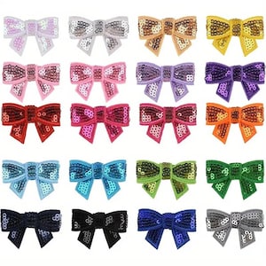 May include: Sixteen sequined bows in a variety of colours, including white, silver, gold, yellow, pink, purple, red, orange, blue, green, and black. Each bow is intricately designed with shimmering sequins, ideal for crafting or embellishing accessories.