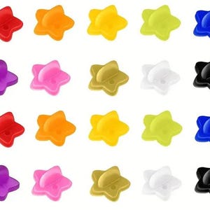 May include: Twenty star-shaped lapel pins in a range of colours: red, orange, yellow, green, blue, purple, pink, gold, white, and black. Each pin has a rounded, three-dimensional design with a pin backing.