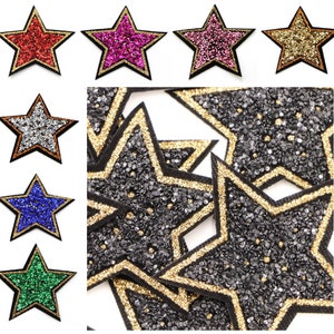 May include: Star-shaped patches in a range of colours: red, pink, gold, silver, blue, and green. Each patch has a glittery surface and a black border with gold trim. Ideal for decorating clothing or accessories. The patches are suitable for embellishing clothing or accessories.