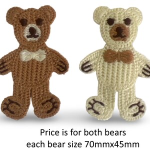 May include: Two knitted teddy bears, one brown and one cream, each with a bow tie. The brown bear has a white bow tie, and the cream bear has a brown bow tie. Each bear measures approximately 70mm x 45mm.