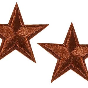 May include: Two brown embroidered star patches. Each star features five points and intricate stitching. These patches are suitable for various crafting and apparel projects, ideal for adding a decorative touch.
