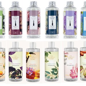 May include: Twelve clear plastic bottles of diffuser refill liquid arranged in two rows. Each bottle features a unique label with botanical illustrations, the text The Scented Home, and a silver cap. The labels display various floral, fruit, and spice imagery.