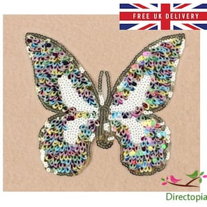 May include: A sequined butterfly applique with a black outline, featuring iridescent and white sequins. The design is set against a beige backdrop. The text "FREE UK DELIVERY" is displayed above the butterfly.