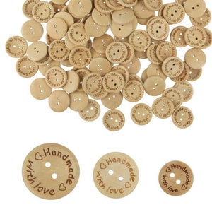May include: A selection of light brown wooden buttons, each with two or four holes. The buttons are engraved with the words "Handmade with love" and a heart symbol. Suitable for sewing and craft projects.