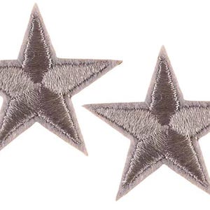 May include: Two grey embroidered star patches. Each star has five points and is filled with detailed stitching. The patches are likely for decorative purposes, such as embellishing clothing or accessories.