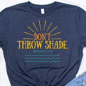 May include: A navy blue t-shirt with a sunburst design and the text "DON'T THROW SHADE."  The text "Ephesians 4:29" is below the main text.