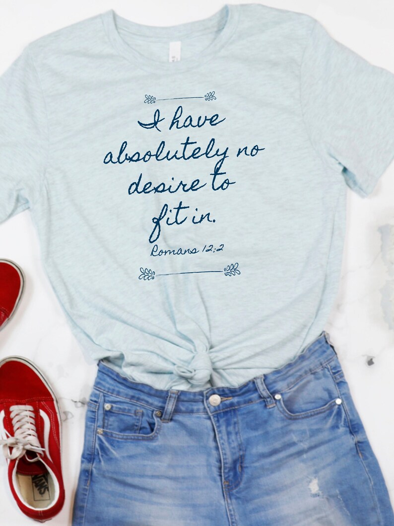 May include: A light blue t-shirt with the text "I have absolutely no desire to fit in. Romans 12:2" printed in dark blue.