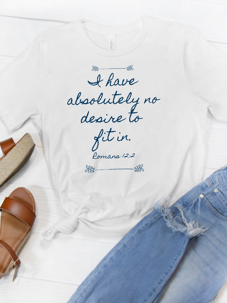 May include: White t-shirt with a blue graphic that says "I have absolutely no desire to fit in. Romans 12:2"