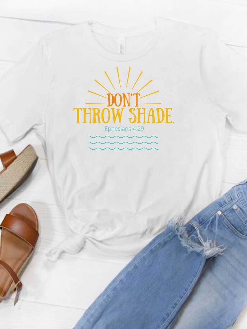 May include: White t-shirt with a yellow sun graphic and the text "Don't Throw Shade. Ephesians 4:29".