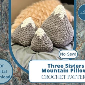 May include: Three gray crocheted mountain-shaped pillows with white peaks. The pillows are arranged on a light gray surface. The text "No-Sew!" is written in black on a white background. The text "Three Sisters Mountain Pillows CROCHET PATTERN" is written in black on a white background. The text "PDF Digital Download" is written in black on a white background.