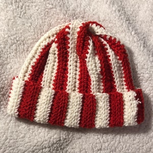 May include: A red and white striped crocheted beanie hat.