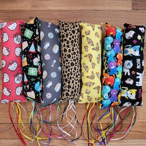 May include: Six colorful catnip toys with different patterns, including Hello Kitty, birthday cake, leopard print, butterflies, and cats. Each toy has a long ribbon attached.