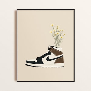 May include: A black, white, and brown sneaker with a bouquet of white daisies growing out of the top. The sneaker is on a beige background.