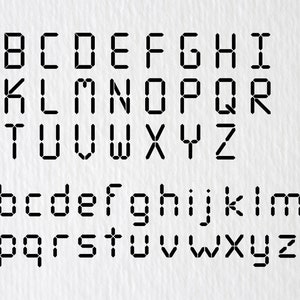 May include: A digital font alphabet in black on a white background. The letters are in uppercase and lowercase. The font is a digital style, with each letter made up of a series of small squares.