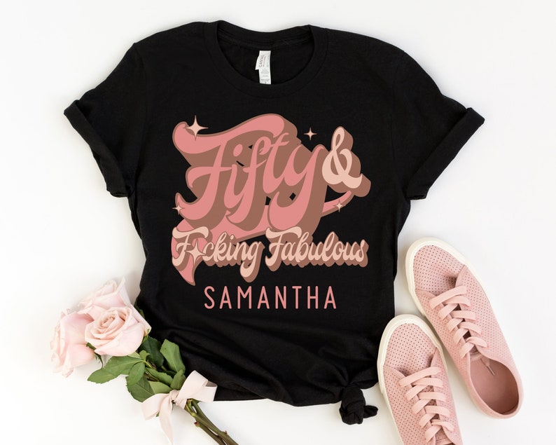 May include: Black t-shirt with a pink graphic that says "Fifty & F*cking Fabulous" with the name Samantha below it.