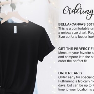May include: A black unisex t-shirt hanging on a wooden hanger. The shirt is part of a clothing collection. Text on the right side provides ordering tips, including sizing and fit information.