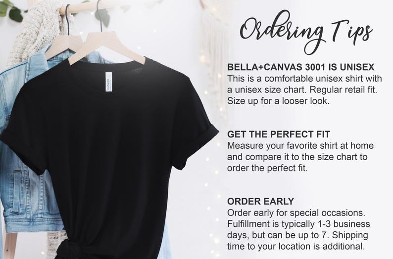 May include: A black unisex t-shirt hanging on a wooden hanger. The shirt is part of a clothing collection. Text on the right side provides ordering tips, including sizing and fit information.