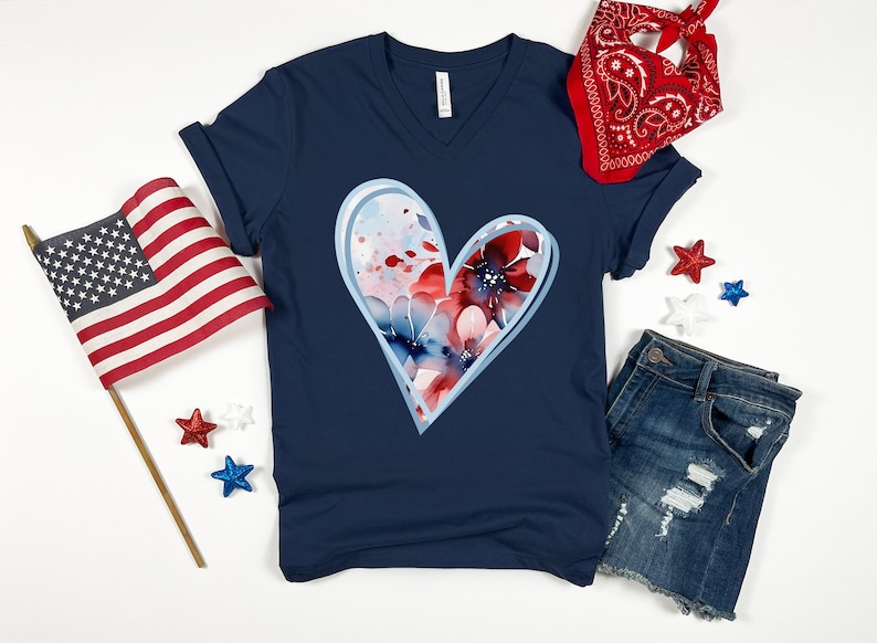 May include: A navy blue t-shirt with a white outline heart design featuring red, white, and blue watercolor flowers.