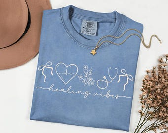 Camisa de enfermera Comfort Colors® con dibujos de enfermería de líneas sencillas y lazos coquetos