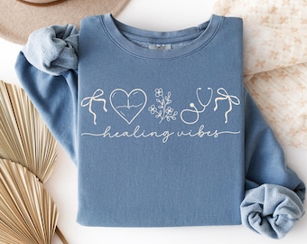 Camisa de enfermera Comfort Colors® con dibujos de enfermería de líneas sencillas y lazos coquetos