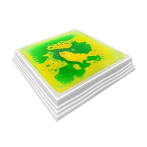 Może przedstawiać: Kwadratowa zabawka sensoryczna z białą ramką i zielono-ż&oacute;łtą cieczą w środku. Ciecz porusza się i tworzy bąbelki.