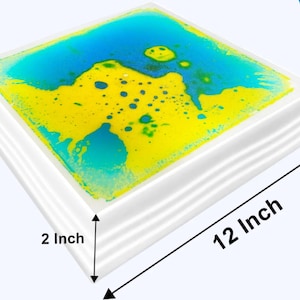 Może przedstawiać: Kwadratowa zabawka sensoryczna z białą ramą i niebieskim i ż&oacute;łtym płynem w środku. Zabawka ma wymiary 30,5 cm x 30,5 cm i grubość 5 cm.