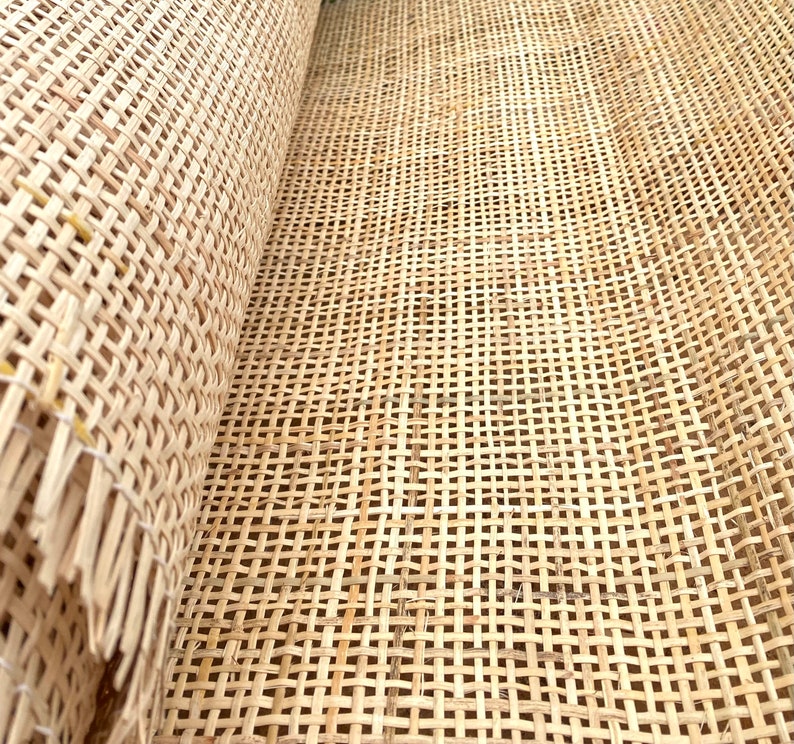 May include: Close-up of a woven cane webbing material, often used for chair seats and backs. The material is light brown and has a tight weave.