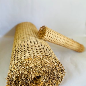 Pode incluir: Dois rolos de tecido de vime natural, um material tecido usado para assentos de cadeiras e outros estofados de m&oacute;veis. Os rolos s&atilde;o feitos de vime natural de cor castanho claro e s&atilde;o enrolados firmemente.