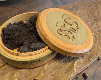 Bolsa de almacenamiento personalizable para snus y nicotina, hecha de latón o imitación madera (disponible en tonos de madera claros u oscuros, latón o acero).