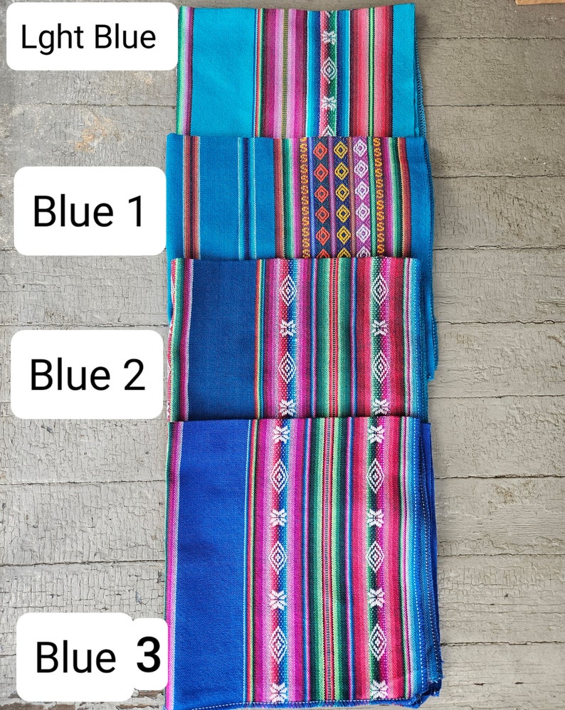 May include: Four fabric squares stacked on top of each other. The top square is light blue with a pink, green, and white striped pattern. The second square is a darker blue with a pink, green, and white striped pattern. The third square is a darker blue with a pink, green, and white striped pattern. The bottom square is a dark blue with a pink, green, and white striped pattern. The squares are labeled "Lght Blue", "Blue 1", "Blue 2", and "Blue 3".