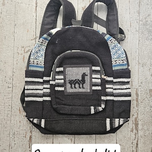 May include: Black backpack with a white and blue striped pattern. The backpack has a single front pocket with a small llama design.