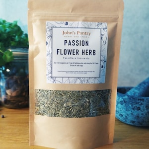 May include: A brown paper bag with a white label that reads "John's Pantry Herbs and Spices Passion Flower Herb Passiflora Incarnata Use 1-2 teaspoons per 1 cup of boiling water and steep for 10-15 min Strain off and enjoy". The bag contains dried passionflower herb.