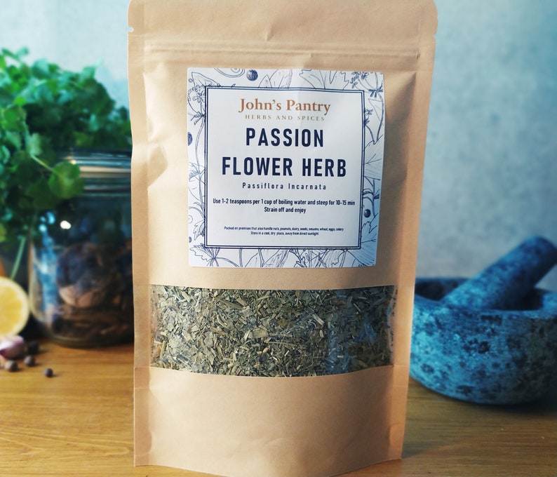 May include: A brown paper bag with a white label that reads "John's Pantry Herbs and Spices Passion Flower Herb Passiflora Incarnata Use 1-2 teaspoons per 1 cup of boiling water and steep for 10-15 min Strain off and enjoy". The bag contains dried passionflower herb.