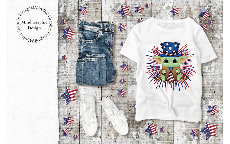 May include: White t-shirt featuring a green character wearing a red, white and blue hat and holding a red, white and blue tie. The character is surrounded by red, white and blue fireworks. The shirt is displayed on a wooden background with blue jeans, white trainers and red, white and blue stars.