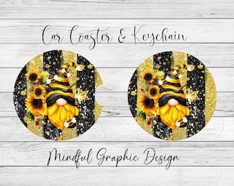 May include: Two round black and gold car coasters with a bee gnome design. The gnome is wearing a black eye mask and a yellow and black striped hat. The design includes sunflowers and glitter accents. The text "Car Coaster & Keychain" is at the top of the image and "Mindful Graphic Design" is at the bottom.